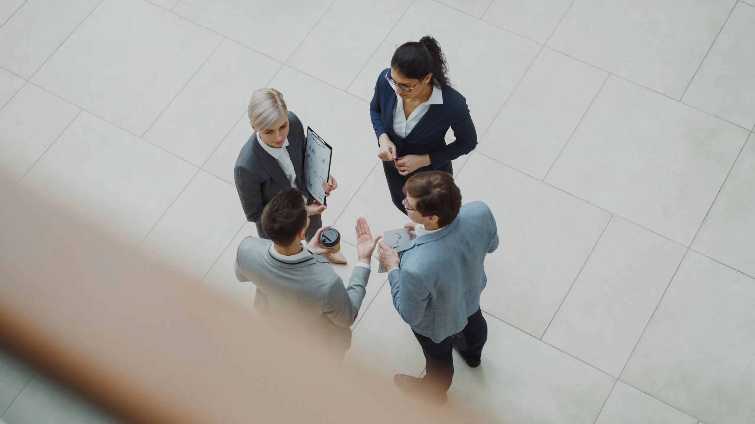 Overhead shot of diverse business team discussing a project indoors.